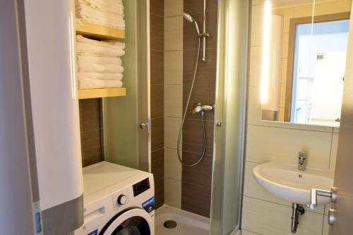 uma casa de banho com um chuveiro e um lavatório. em K&K Apartment Siófok em Siófok