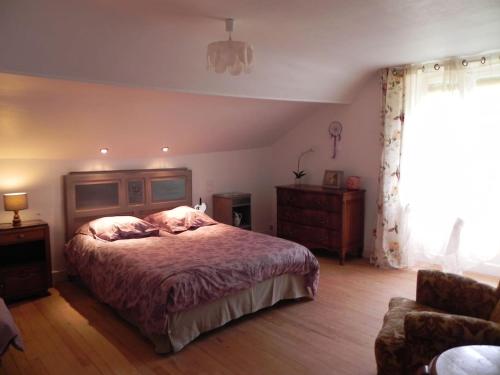- une chambre avec un lit, un canapé et une fenêtre dans l'établissement L atelier d Ombeline, à Bonnal