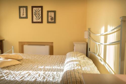 a bedroom with a bed and three pictures on the wall at Agriturismo Il Giardino Dei Ciliegi in Passaggio Di Assisi