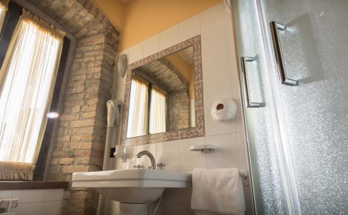 a bathroom with a sink and a mirror and a shower at Agriturismo Il Giardino Dei Ciliegi in Passaggio Di Assisi