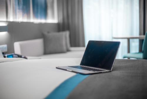 a laptop computer sitting on top of a bed at Holiday Inn Express Manila Newport City, an IHG Hotel in Manila