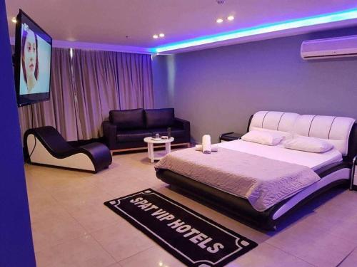 sypialnia z łóżkiem typu king-size i telewizorem w obiekcie Spat Rooms VIP w mieście Petach Tikwa