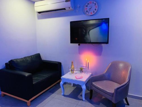 a living room with a couch and a table and a tv at Spat Rooms VIP in Petaẖ Tiqwa