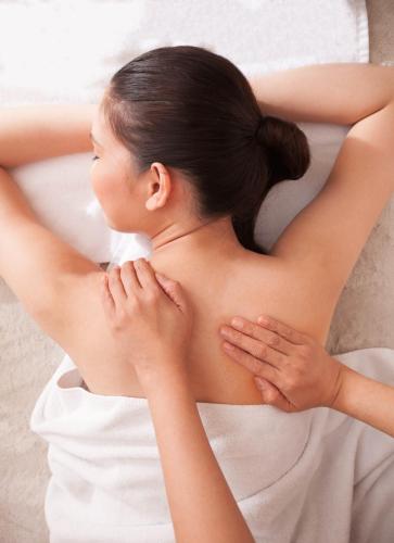 a woman laying on a bed with her hands on her back at Diamond Hotel Philippines in Manila