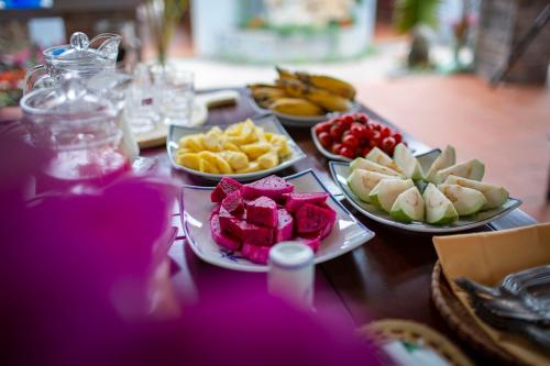 a table topped with plates of food and fruit at Bai Dinh Garden Resort & Spa in Ninh Binh