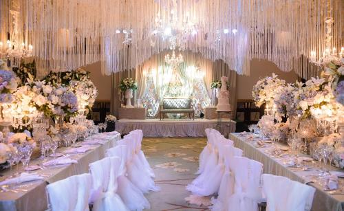 a banquet hall with white tables and chairs and chandeliers at Diamond Hotel Philippines in Manila