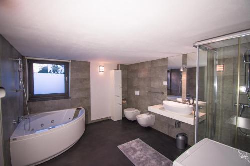 Un baño con dos lavabos y una bañera y dos inodoros. en Villa Sunrise Premantura Sea View, en Premantura