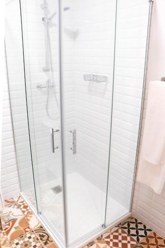 a shower with a glass door in a bathroom at Hostal Castillo in San José de la Rinconada
