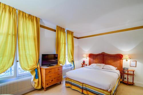 a bedroom with a bed and a flat screen tv at Villa Escudier Appart-hôtel in Boulogne-Billancourt