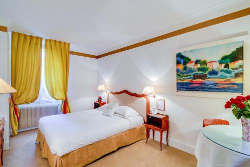 a hotel room with a bed and a table at Villa Escudier Appart-hôtel in Boulogne-Billancourt