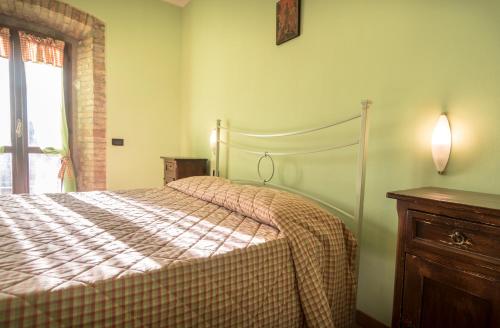 a bedroom with a bed and a dresser and a window at Agriturismo Il Giardino Dei Ciliegi in Passaggio Di Assisi
