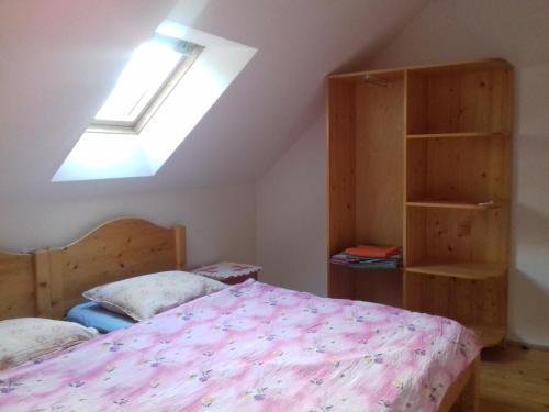 a bedroom with a bed and a skylight at Casa din prund Ocolis in Ocoliş