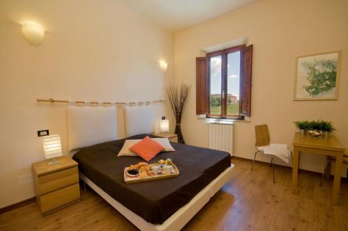ein Schlafzimmer mit einem Bett und einem Tablett mit Essen drauf in der Unterkunft Dolce Notte in Pisa