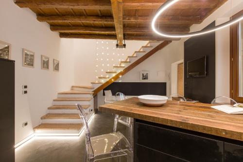 uma cozinha com um balcão com um lavatório e escadas em Casa Savio em Verona