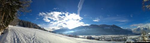 a snow covered slope with the sun in the sky at Holiday Home Zillertal - Haus Gigl in Bruck am Ziller