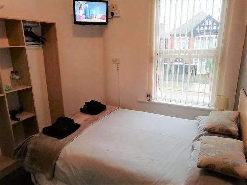 a bedroom with a large bed and a tv on the wall at The Penrhyn in Blackpool