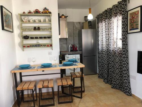 a kitchen with a table and chairs and a refrigerator at MP Cozy Apartment Near the Sea in Paphos City