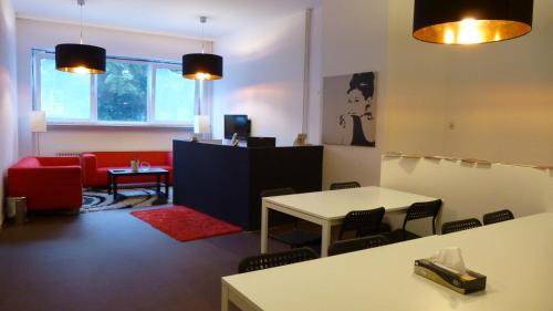 una sala d'attesa con un divano rosso e un tavolo di The Hostel ad Amburgo