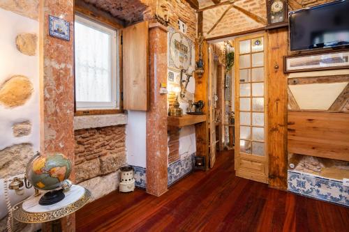 Cette chambre est dotée d'un mur en pierre et d'une porte avec une télévision. dans l'établissement Romantic Medieval Apartment, à Lisbonne