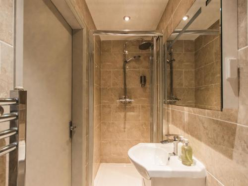 ein Bad mit einem Waschbecken und einer Dusche in der Unterkunft White Lion Hotel in Crewe
