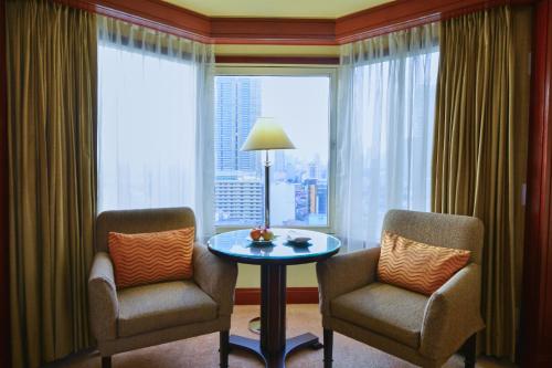 
a living room filled with furniture and a window at Diamond Hotel Philippines - Multiple Use Hotel in Manila
