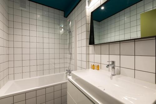 a bathroom with a sink and a mirror and a tub at Veeve - Bois de Boulogne Retreat in Paris