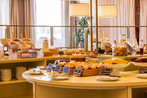 a buffet line with bread and other food on a table at Hotel Boffenigo - The Golden Hour in Costermano sul Garda