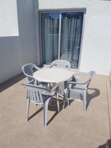 a white table and chairs in a room with a window at Eleni Apartments in Ayia Napa