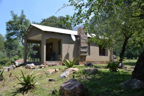 a small house in the middle of a yard at Rocky Drift Private Nature Reserve in Waterval Boven