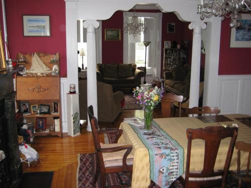 una sala de estar con una mesa con un jarrón de flores. en Historic Hill Inn, en Newport