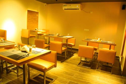 a restaurant with tables and chairs in a room at HOTEL KEK GRAND PARK in Chennai