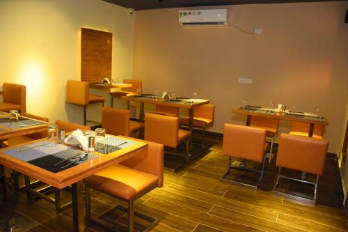 a restaurant with tables and chairs in a room at HOTEL KEK GRAND PARK in Chennai