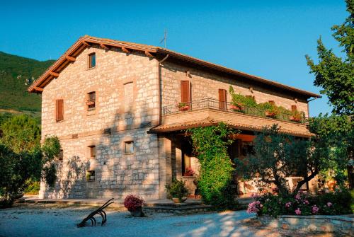 a large stone building with a balcony on it at Agriturismo Il Giardino Dei Ciliegi in Passaggio Di Assisi