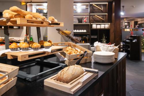 a bakery with bread and pastries on a counter at Chalet Hôtel Le Prieuré & Spa in Chamonix-Mont-Blanc