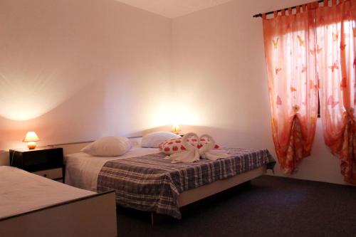 a bedroom with two beds and a window at Apartments Marinović 3462 in Supetar