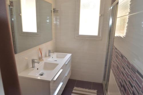 a white bathroom with a sink and a shower at 4 Rue Guigonis in Nice