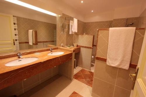 a bathroom with two sinks and a shower at Hotel Moderne Et Pigeon in Limoux