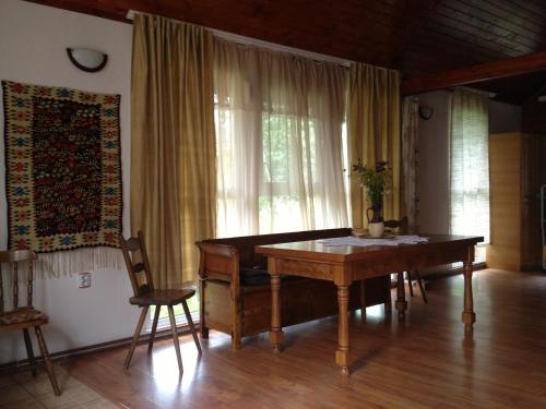 una sala da pranzo con tavolo in legno e finestra di Kings Valley Retreat Apuseni Mountains a Câmpeni