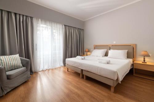 
a hotel room with a large bed and a large window at Sun Beach Lindos in Lardos
