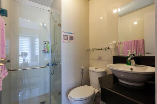 een badkamer met een douche, een toilet en een wastafel bij Condo near Terminal 3 in Manilla