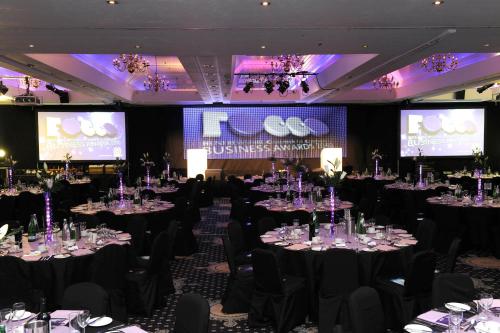 a ballroom with tables and chairs with tablesktop at Normandy Hotel (Near Glasgow Airport) in Paisley