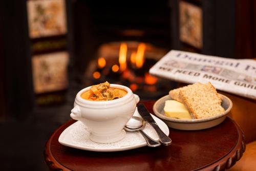 ein Tisch mit einer Schüssel Essen und einem Teller Käse in der Unterkunft The Highlands Hotel in Glenties