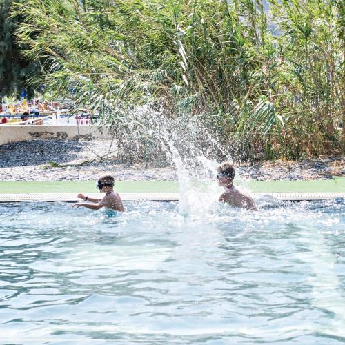 two boys are playing in a swimming pool at Sun Beach Lindos in Lardos