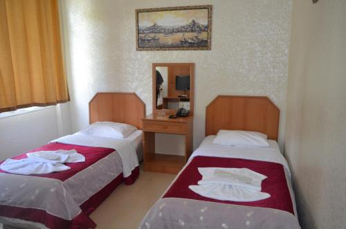 a hotel room with two beds and a mirror at Ekol Hotel in Istanbul