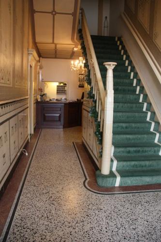 a staircase in a house with a green carpet at Hotel restaurant Stad Munster in Winterswijk