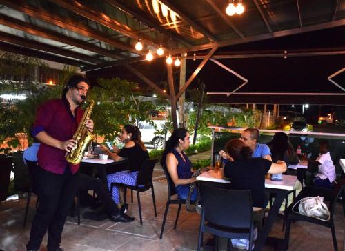 a man playing a saxophone in a restaurant at Hotel Milla de Oro Uraba in Apartadó