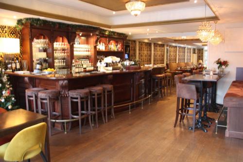 a bar in a restaurant with bar stools at Hotel restaurant Stad Munster in Winterswijk
