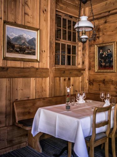 a dining room with a table and a chandelier at Hotel Schönegg in Wengen