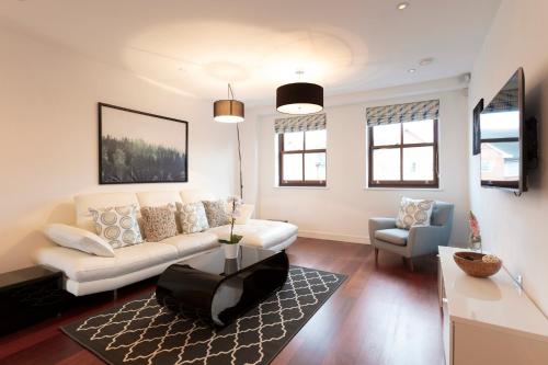 a living room with a white couch and a chair at Hampden Apartments - The Henry in Windsor