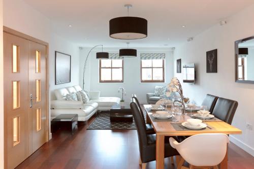 a living room with a table and a couch at Hampden Apartments - The Henry in Windsor
